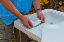 Load image into Gallery viewer, Man demonstrating how to use the refuse hole with easy-snap locking system to easily hold a trash bag in place.